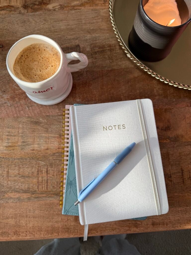 coffee mug and notebook on wooden table